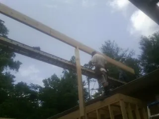 Carpenter setting a ridge beam over a new addition frame — Ice Dam Removal by Roofing Brothers in Rockland