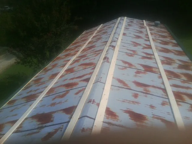 Rusted metal roof panels with new wood purlins before replacement — Storm Damage Roof Repair in Rockland by Roofing Brothers