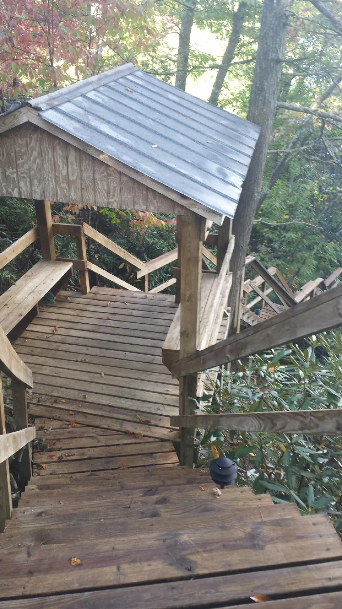 Metal roofed shelter over wooden steps on a wooded walkway — Skylight Repair & Installation work by our crew in Rockland